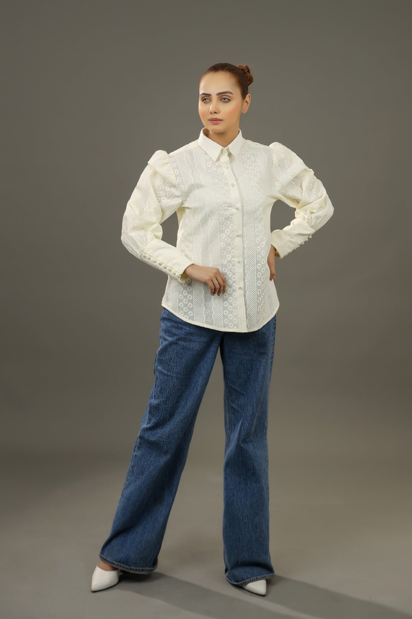 Woman wearing a white blouse and blue jeans against a gray background.-Embroidered summer-women-Shirt-Relaxed body fit-Structured collar-Pearl buttons-Unlined-Long balloon sleeve with long cuffs-Fabric: 100% Cotton