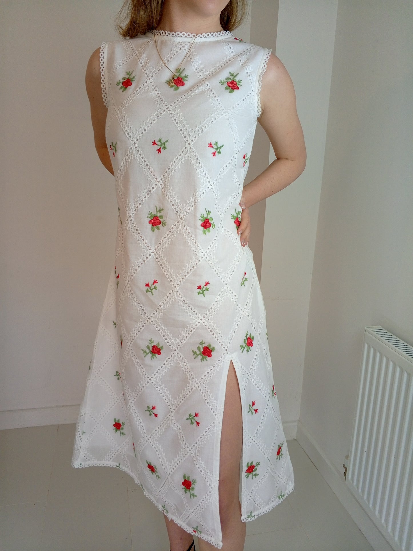 White dress with red floral embroidery worn by a person against a plain background with premium Organic-_cotton-white-summer-woman-dress-red-floral-frontside-closeup