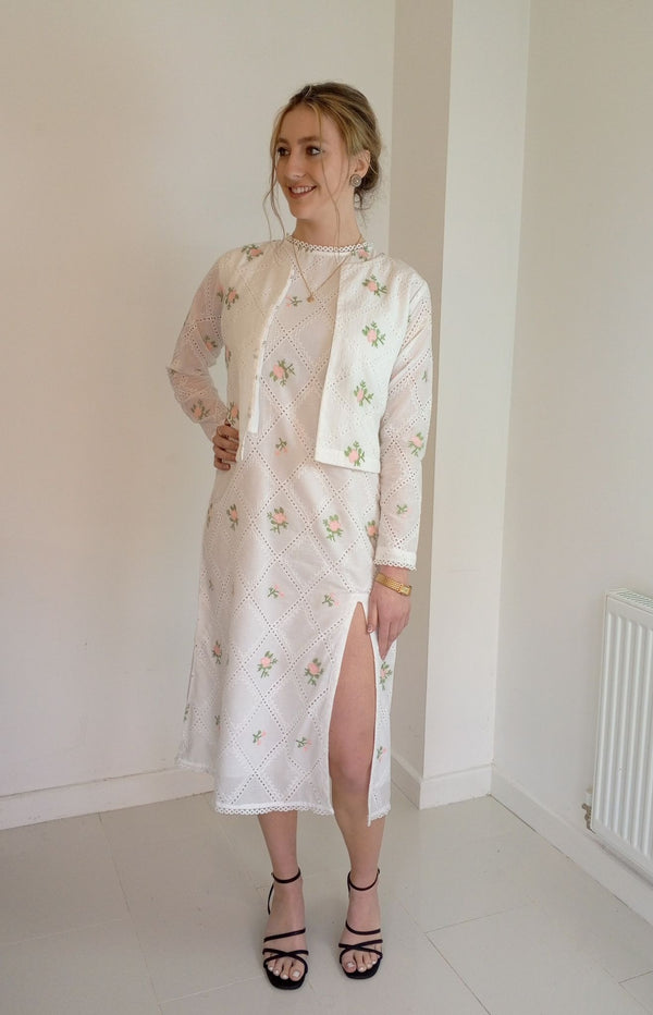 Woman wearing a white embroidered dress with Cropped pink embroidered cardigan-Relaxed body fit-Round neck -Inside hidden hook closure-full lined body with100% soft fine cotton-Long sleeves with lace -Fabric: 100% Cotton-sideangle