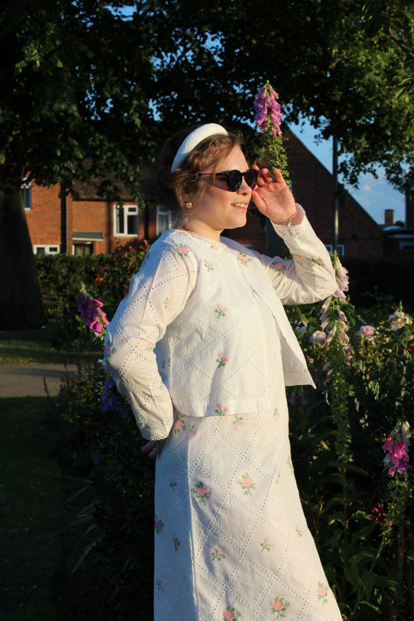 Woman in a white dress with floral Cropped pink embroidered cardigan-Relaxed body fit-Round neck -Inside hidden hook closure-full lined body with100% soft fine cotton-Long sleeves with lace -Fabric: 100% Cotton