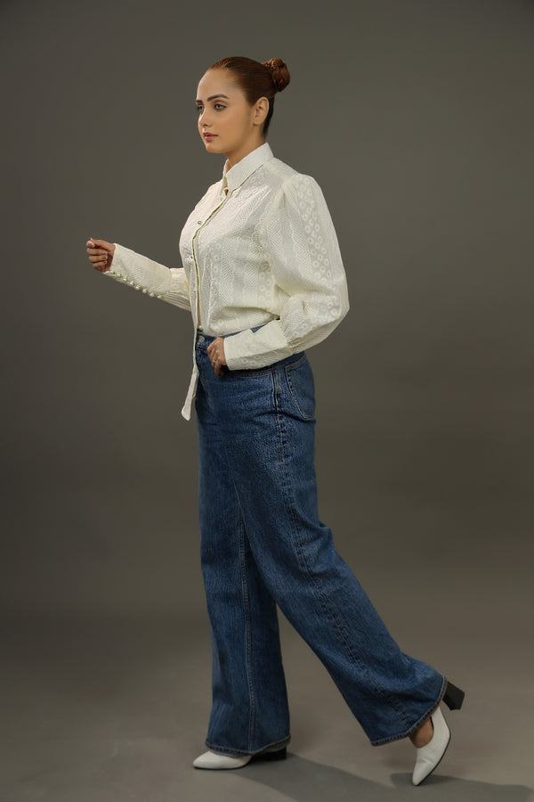 Woman wearing a white blouse and blue jeans on a gray background.-Embroidered  summer-women-Shirt-Relaxed body fit-Structured collar-Pearl buttons-Unlined-Long balloon sleeve with long cuffs-Fabric: 100% Cotton blouse-sideview