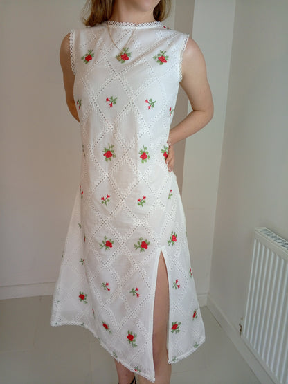 White dress with red floral embroidery worn by a person against a plain background with premium Organic-_cotton-white-summer-woman-dress-red-floral-frontside-closeup